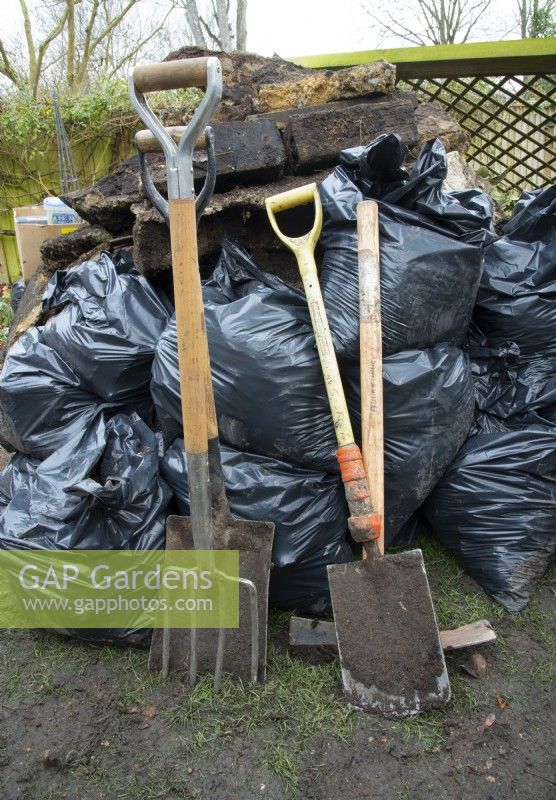 Shovels and a pitch fork with long-handled D-shaped handles being used in the make over of a small London Garden.
