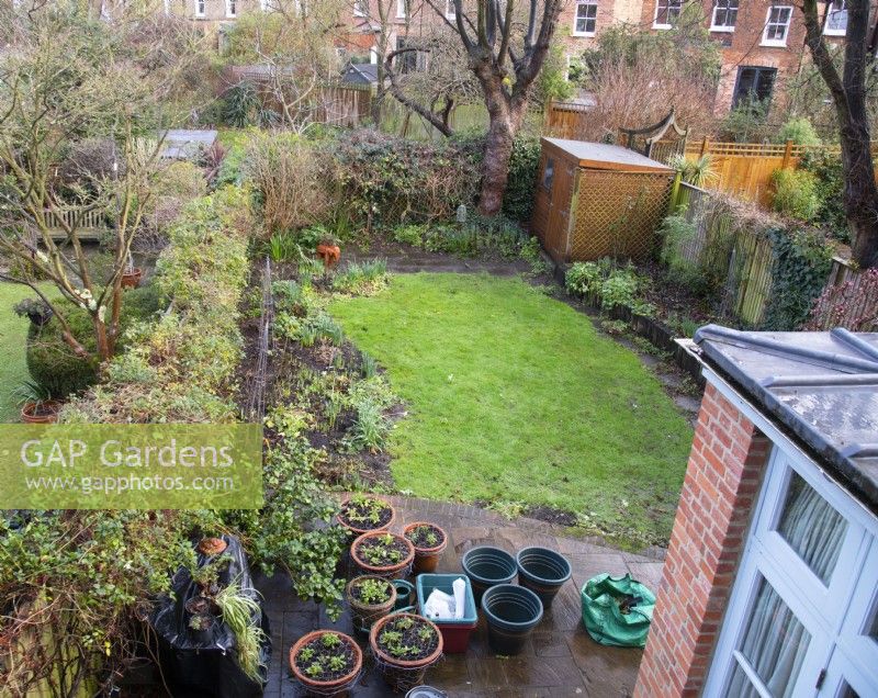 A 'Before' photo of a London garden awaiting a makeover.  Part of the remit was to replace the railroad sleepers and stone path around the raised bed with a brick wall and path and to extend the front and rear terraces.