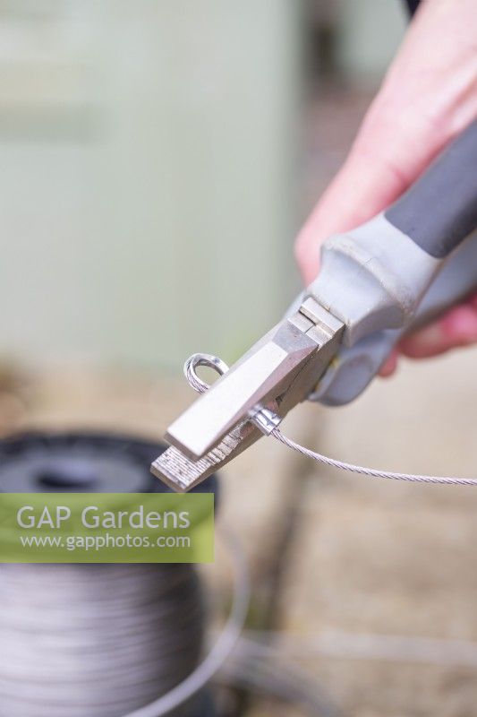 Woman using pliers to crimp ferrules on the wire