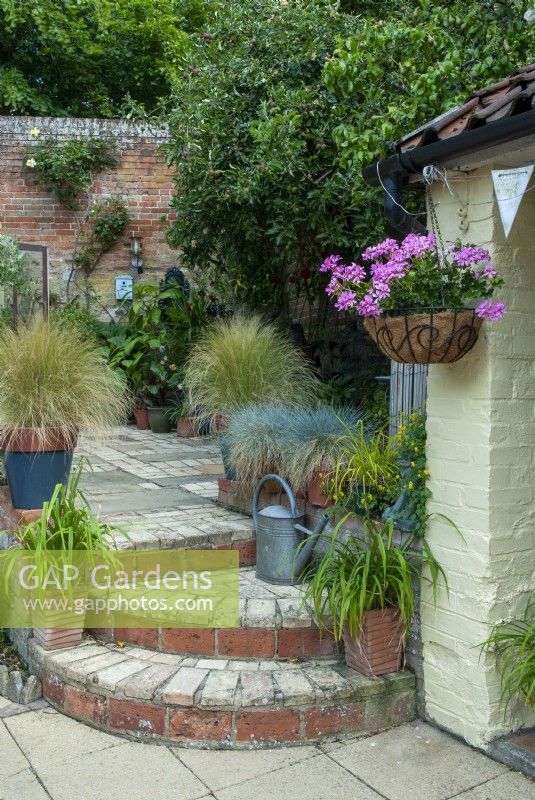 Courtyard patio with steps to lower level, container planting and  hanging basket - Open Gardens Day, Coddenham, Suffolk