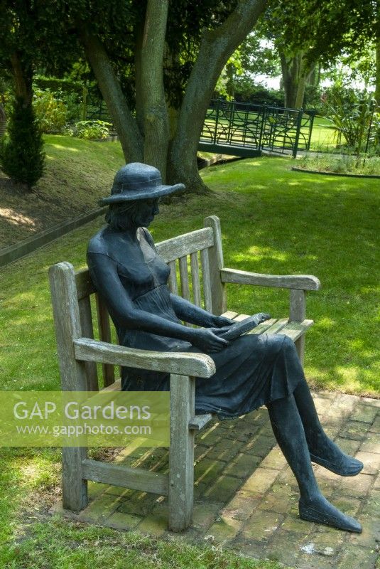 Metal statue of lady reading a book seated in shaded area of the garden - Garden Festival Day, Fressingfield, Suffolk
