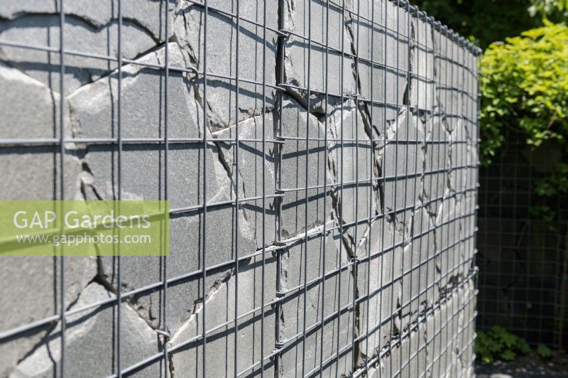 Garden feature. Gabion cage walls filled with stone crazy paving style