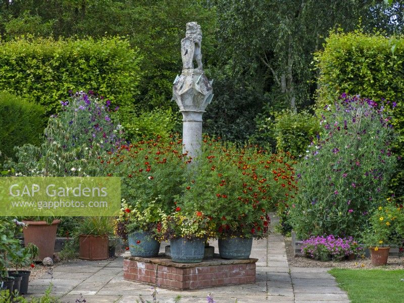 The Scottish Sundial and metal containers with Marigolds Old Vicarage Gardens  East Ruston Norfolk July Summer