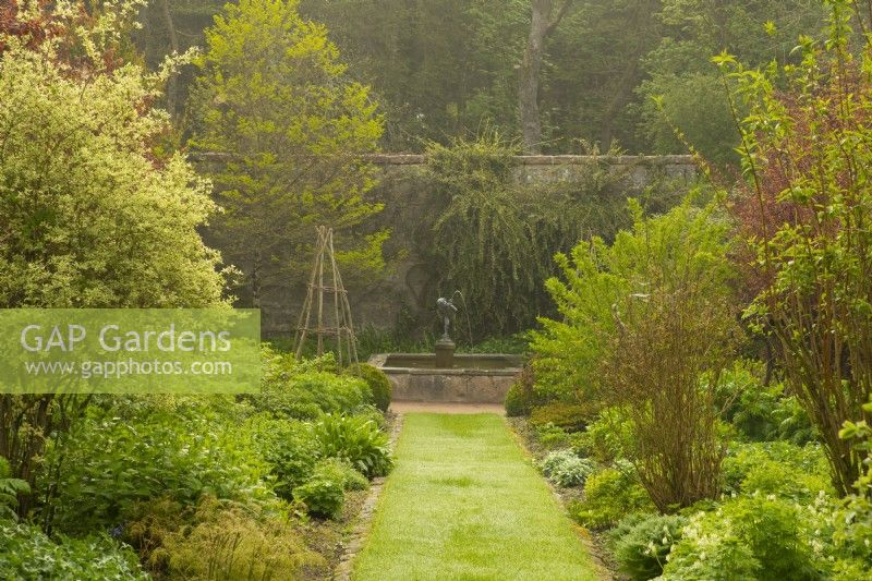 A lawned path through the white border leading to a cupid fountain in the Crathes Castle Walled Garden