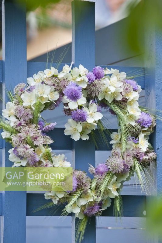 Heart shaped wreath containing mock orange, field scabious, astrantia and wheat.