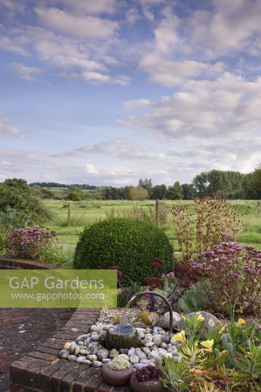 Water feature on a raised bed in a country garden in September