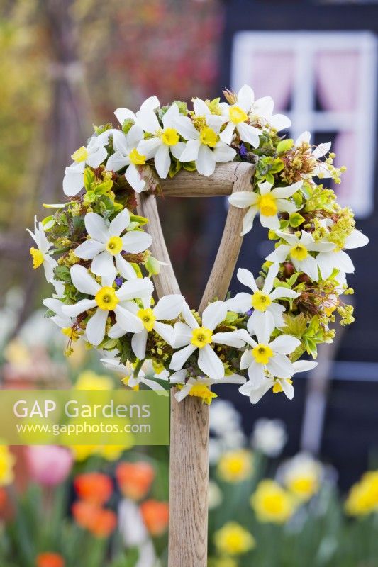 Spring wreath made of daffodils and maple twigs attached to a handle.