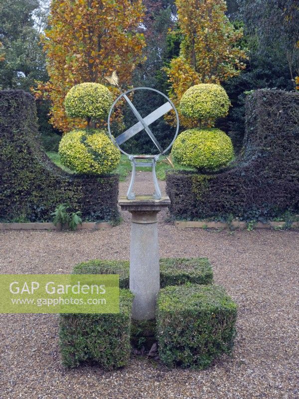 Armillary Sun Dial with Clipped Buxus - Box - hedging and topiary in the tea garden at - East Ruston Old Vicarage, Norfolk.