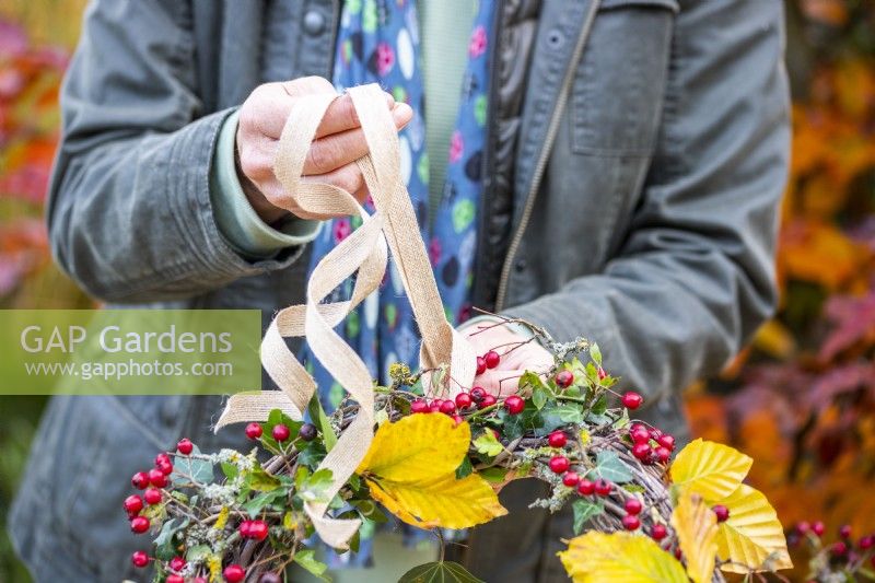 Woman tying ribbon onto the wreath