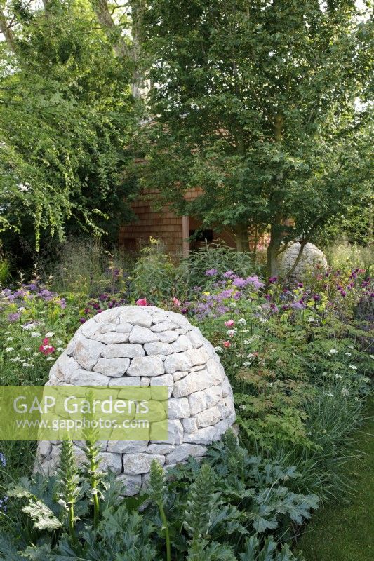Stone cairns sit amongst the herbaceous planting including Acanthus 'Rue Ledan' in Horatio's Garden - Designer: Charlotte Harris and Hugo Bugg  -Sponsor: Project Giving Back -