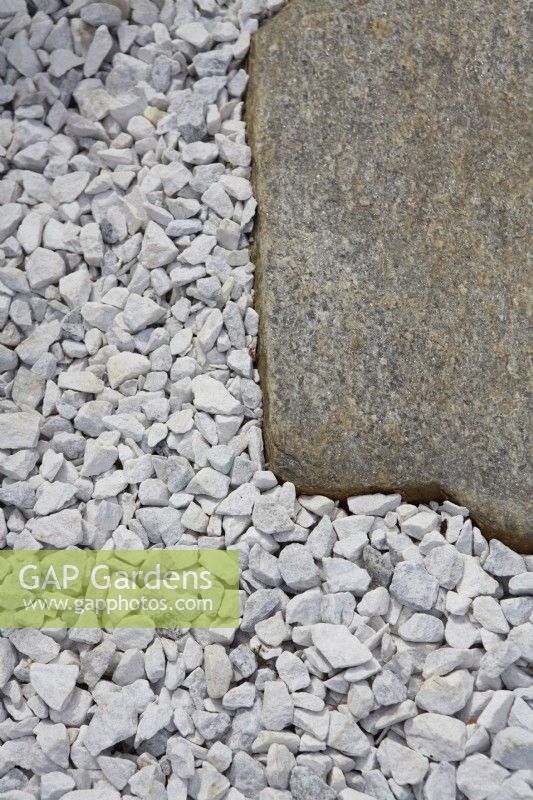 Detail of irregular stone slabs set into white gravel.