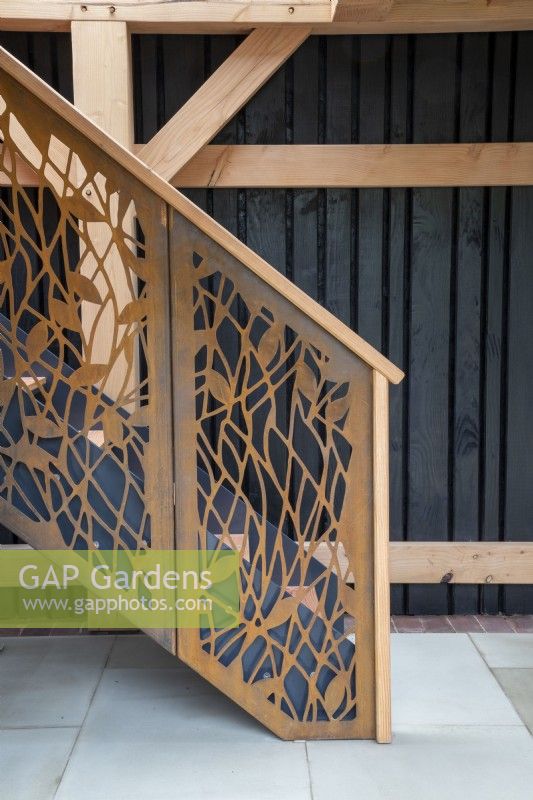 Ornate staircase made from corten steel in an oak frame building with stone paving 