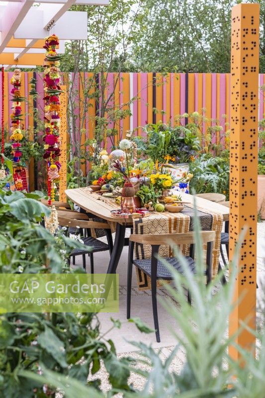 View of dining area decorated in Indian style with colourful flowers, fruits and spices.The RHS and Eastern Eye Garden of Unity, Designer: Manoj Malde