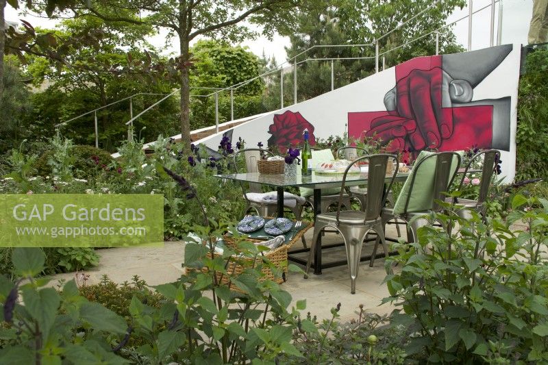 RHS Chelsea Flower Show 2023 - Dining area amongst flower borders - Cavernoma On My Mind designed by Taina Suonio and Anne Hamilton Silver