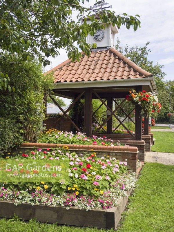 Flower beds and hanging baskets surrounding bus stop at Filby village in bloom Norfolk 2023