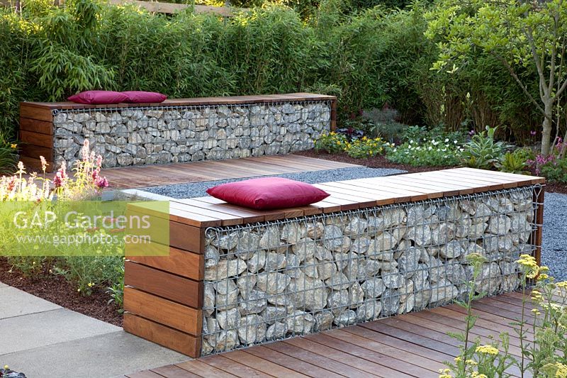 Gabion as a seating area in front of a bamboo hedge 