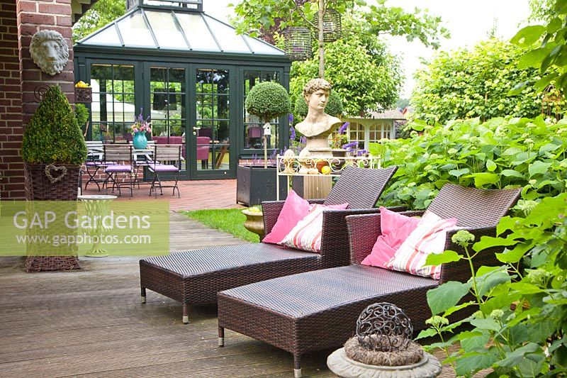 Seating area on the terrace with hedge of hydrangeas, Hydrangea arborescens Annabelle 