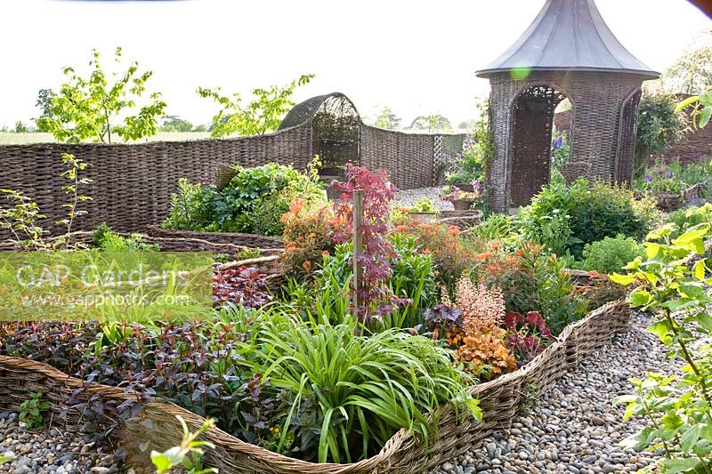 Cottage garden with willow-bordered beds and willow pavilion 