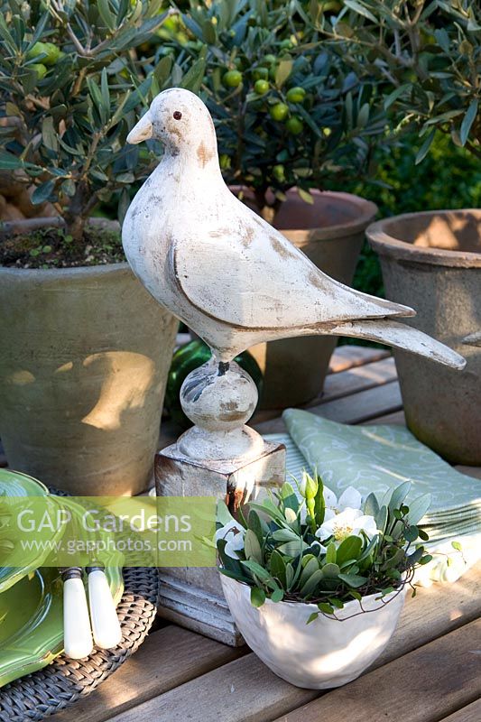 Olive branches and rose blossom in bowl as table decoration 