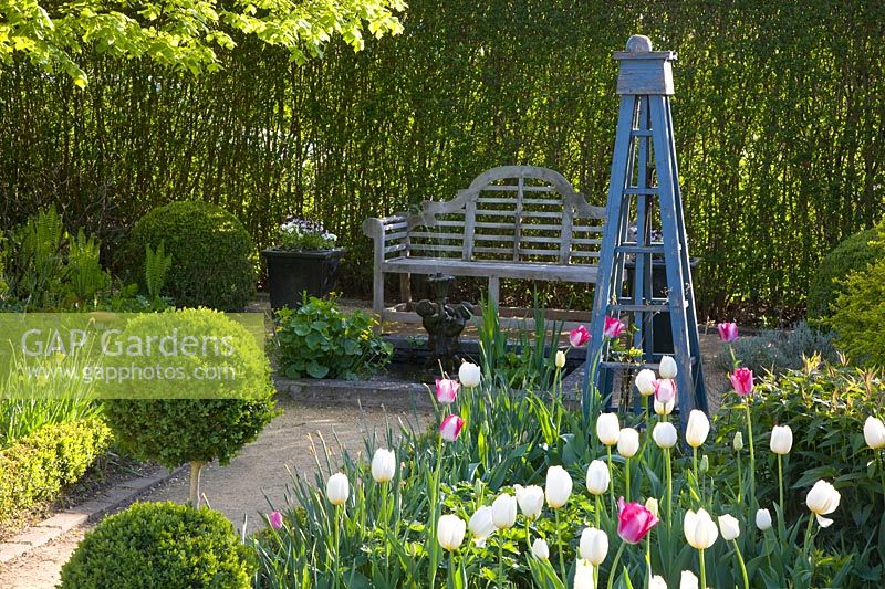 Seating area with tulips and obelisk 