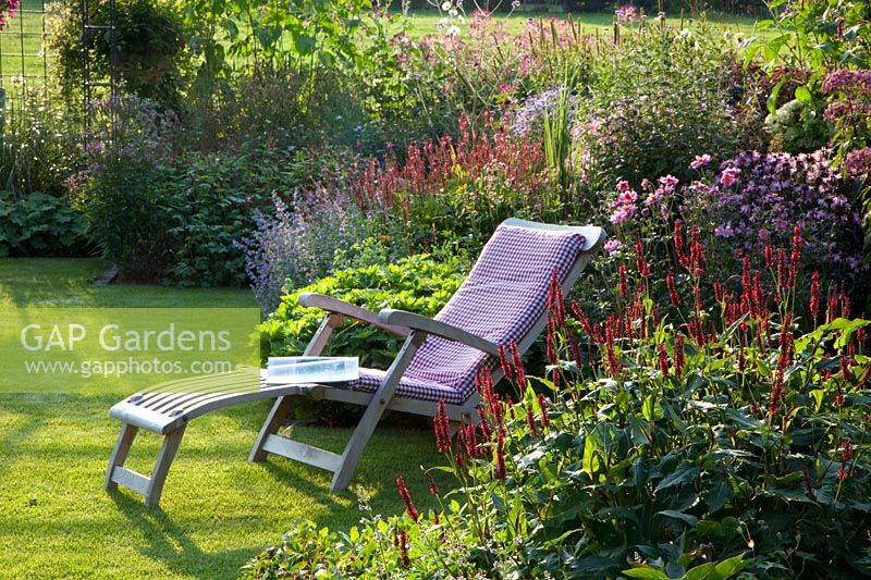 Seating area in front of perennial bed 