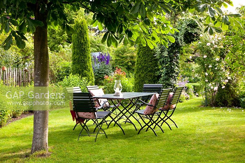 Seating under chestnut tree in the garden, Aesculus 