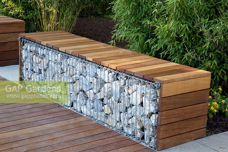 Gabion as a seating area in front of a bamboo hedge 