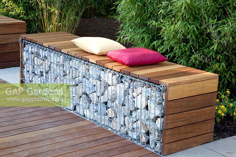 Gabion as a seating area in front of a bamboo hedge 