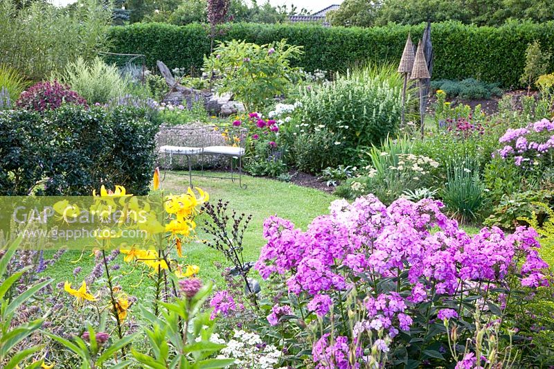 Perennial bed with seating area in July 