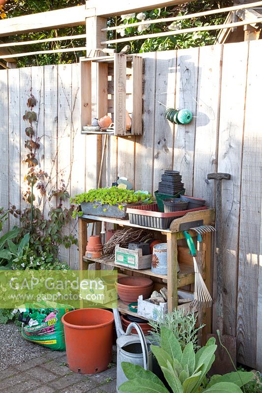 Work table in the garden in front of a wooden privacy screen 