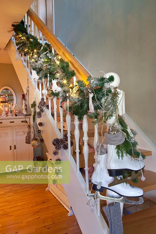 Christmas decorated staircase with garland and ice skates 