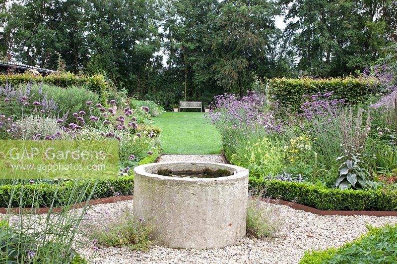 Bed with perennials and annuals and fountain in the middle, Verbena bonariensis; Nicotiana langsdorfii 
