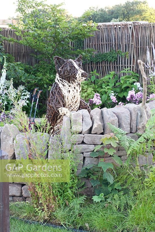 Natural stone wall and dog made of willow 