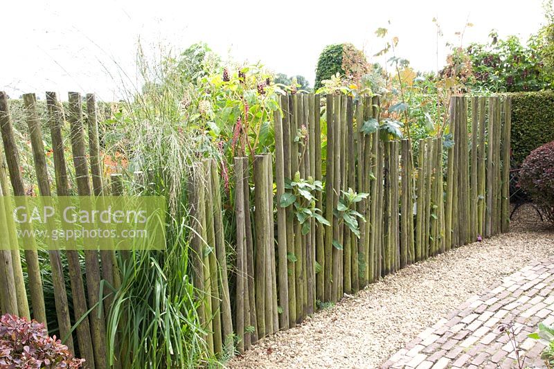 Fence made of round timbers of different heights 