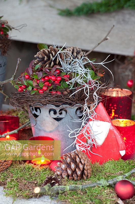 Metal pot decorated with natural material and mock berries 