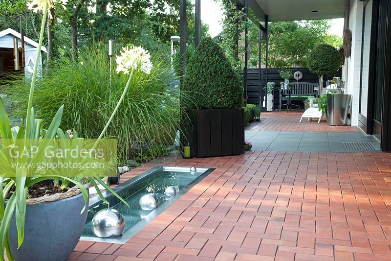 Terrace with clinker paving and stainless steel pool 