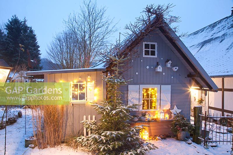 Illuminated garden house in winter 