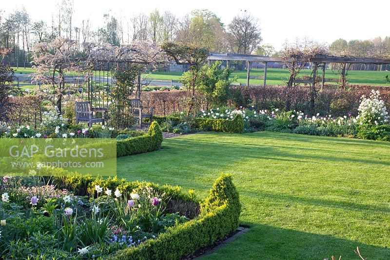 Spring garden with arbor and bulb flowers 