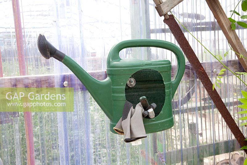 Watering can as a container for garden accessories 
