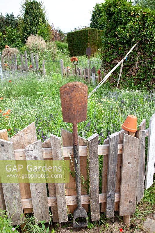 Fence made of old wooden boards and garden tools 