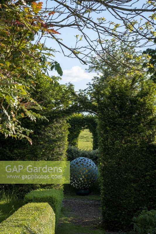 'Mantle' an artwork by David Harber set amongst clipped hedges
