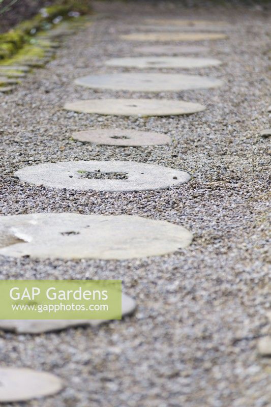 Millstones set into a gravel path at York Gate Garden in February