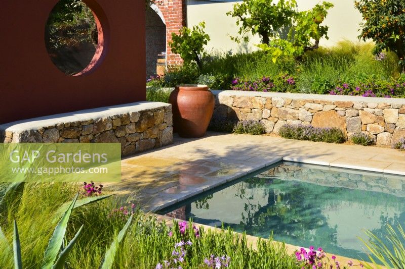 Mediterranean garden with orange wall compartmentwith a circle window, pool and stone raised bed. June
Designer - Alan Rudden