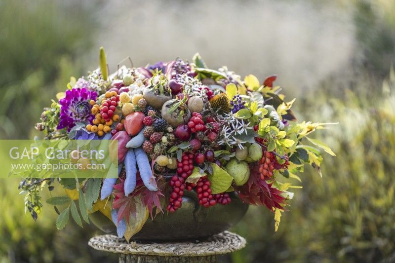 Bouquet of autumn flowers, leaves and edible fruits