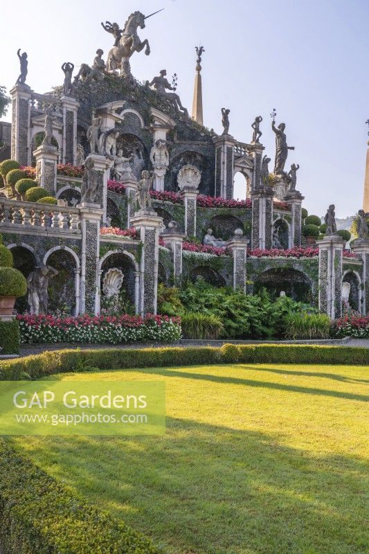 The Italian-style formal baroque Garden Isola Bella with complex structure of Teatro Massimo linked by staircases and decorated with statues, obelisks, floral arrangements and well manicured green lawns surrounded by trimmed hedges.