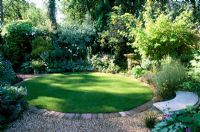 Shady garden with circular lawn, mixed planting and seating. Ladywood in Hants 