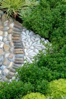 Decorative pebble paving edged with Festuca glauca 'Golden Toupee', Sempervivum tectorum, Thymus and Saxifraga moschata 'Cloth of Gold'.