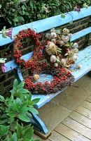 Display of wicker wreaths on painted blue bench