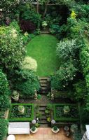 Overview of small town garden with shaped lawn and steps at Campden Hill Terrace, London. 