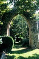 Gothic ruin in wild, natural garden setting at Mannington Hall garden, Norfolk